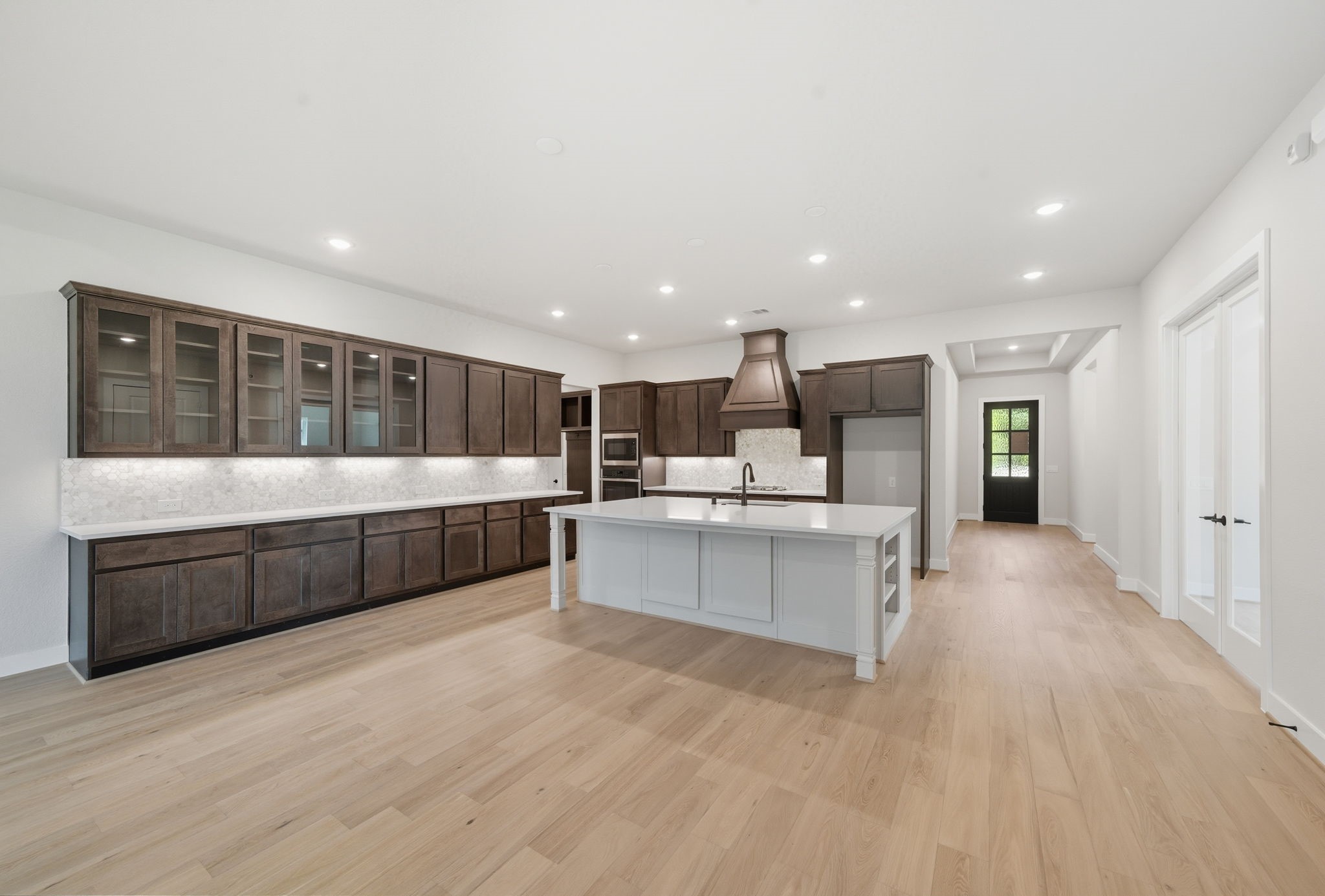 10041 Larkin Cove Willis, TX 77318 - Photo 15 of 48 a large white kitchen with stainless steel appliances kitchen island a large counter top and a wooden floors