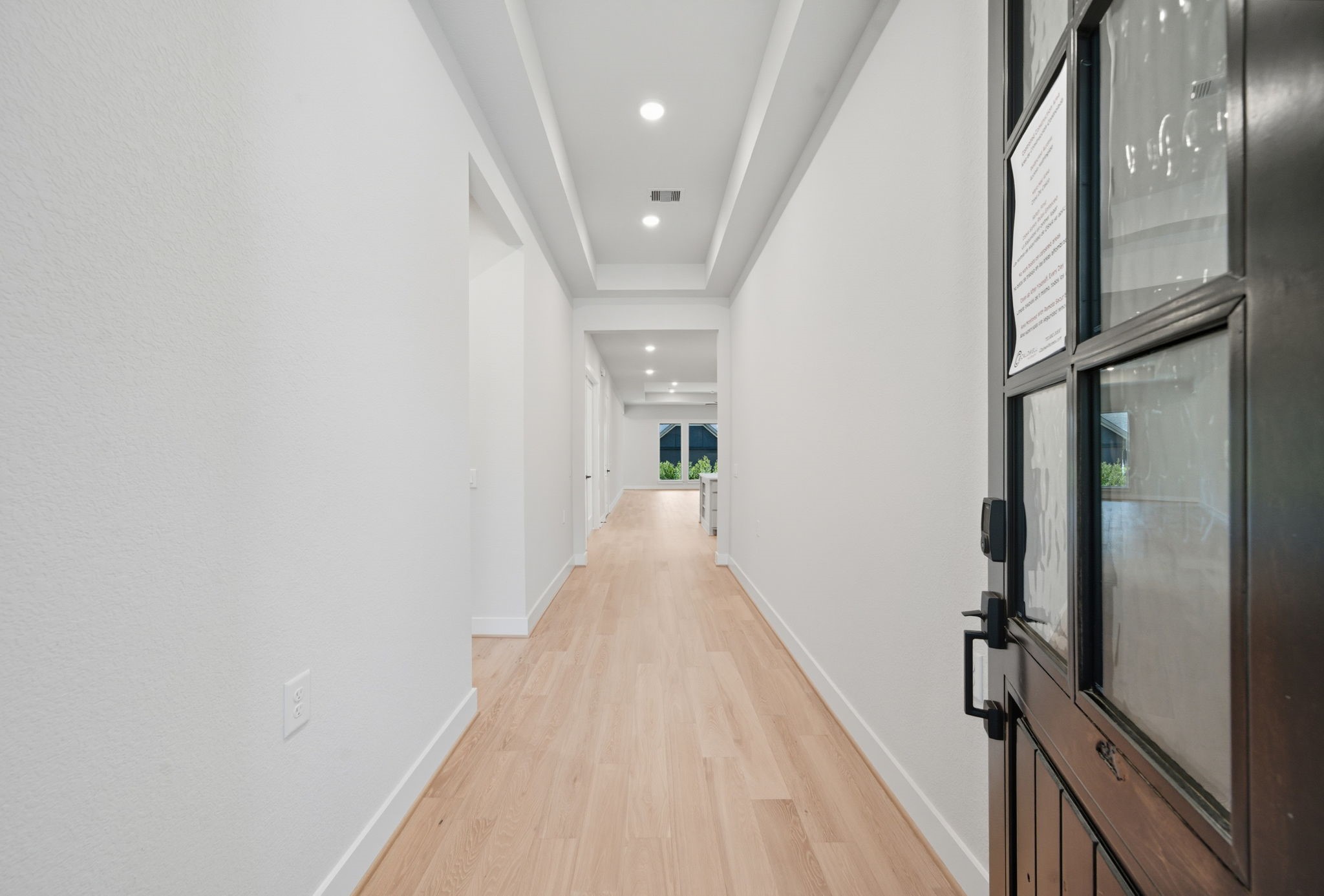 10041 Larkin Cove Willis, TX 77318 - Photo 3 of 48 a view of a hallway with wooden floor and a chandelier