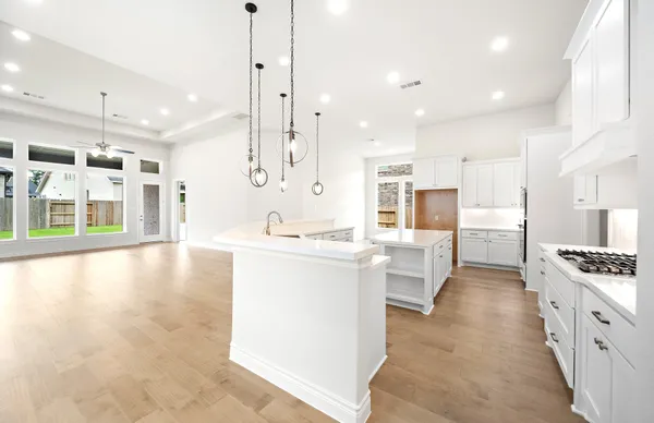 a large kitchen with kitchen island white cabinets and stainless steel appliances