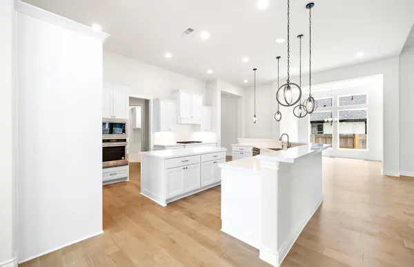 a kitchen with white cabinets and sink