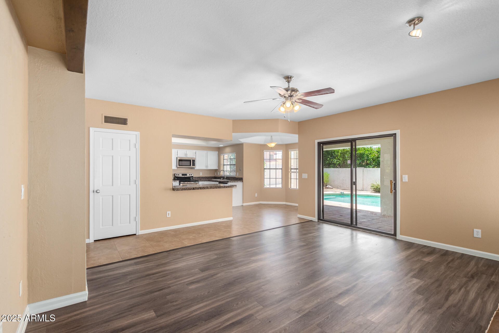 6121 East Saddleback Street Mesa, AZ 85215 - Photo 13 of 36 a view of a livingroom with wooden floor and a ceiling fan