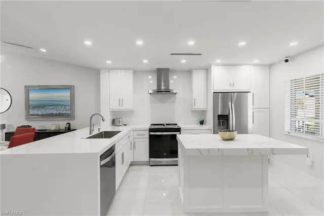 a kitchen with a sink a refrigerator and white cabinets