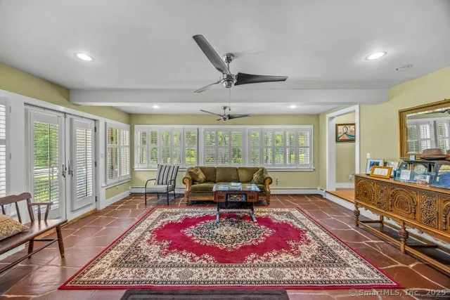 a living room with furniture a rug and a large window