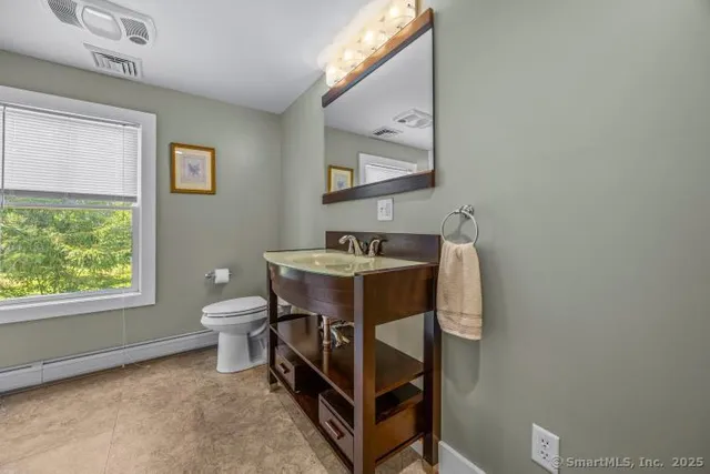 a bathroom with a sink toilet and a mirror