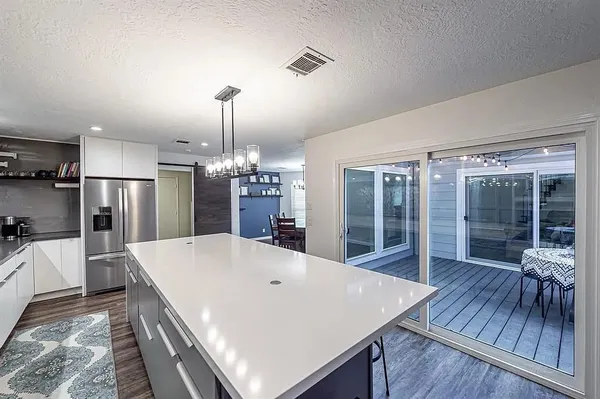 a large white kitchen with a large window and stainless steel appliances