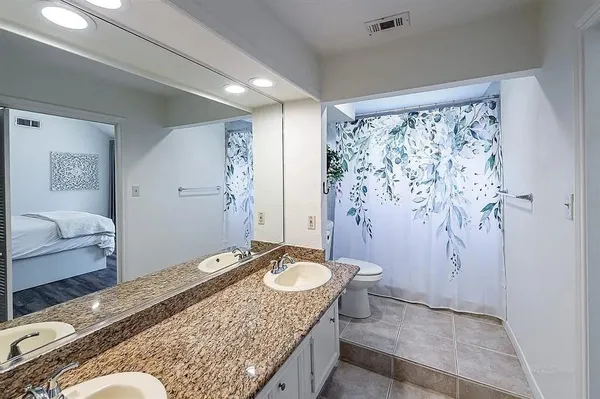 a bathroom with a granite countertop sink and a mirror