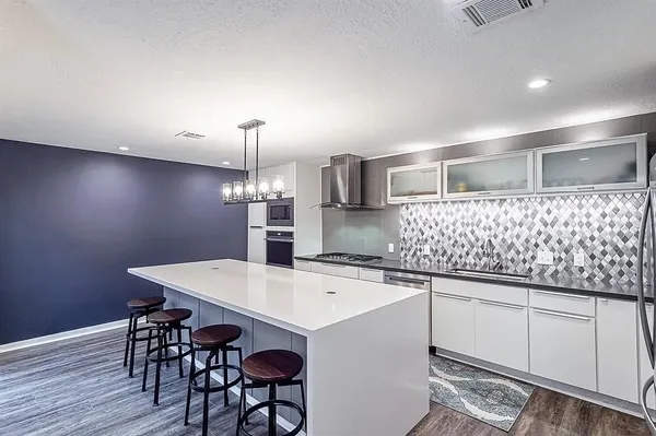a kitchen with a sink cabinets and wooden floor