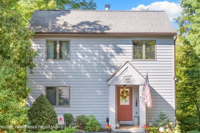 a view of a brick house with windows and plants