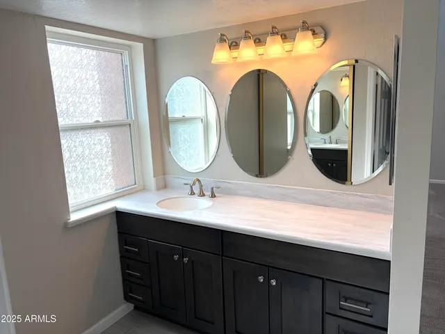 an empty room with windows and fireplace