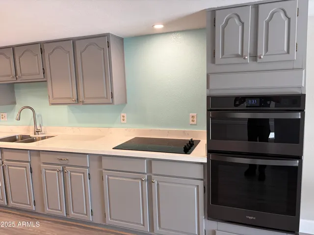 a kitchen with white cabinets and sink