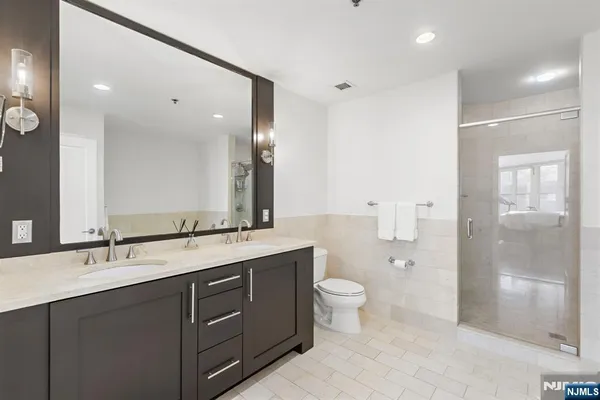 a bathroom with a double vanity sink mirror and toilet