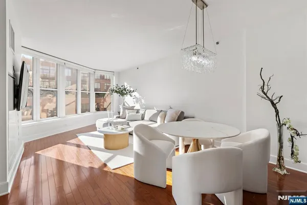 a dining room with furniture a chandelier and wooden floor