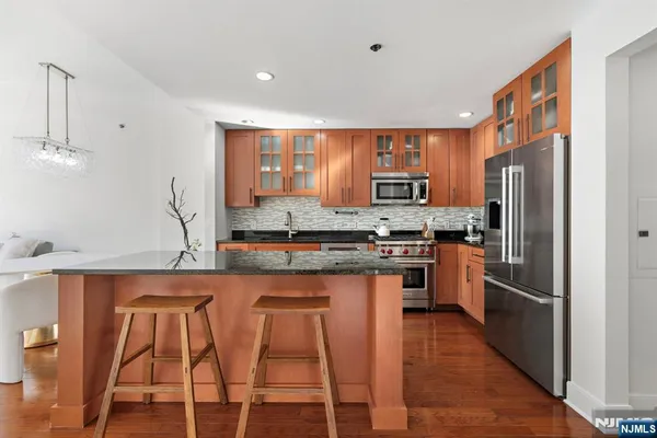 a kitchen with stainless steel appliances granite countertop a refrigerator and a stove top oven