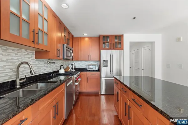 a kitchen with granite countertop a sink and cabinets