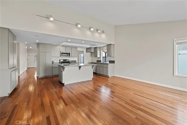 a view of kitchen view wooden floors appliances and cabinets