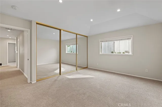 an empty room with windows and closet