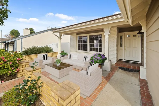 a view of a patio with couches table and chairs and potted plants