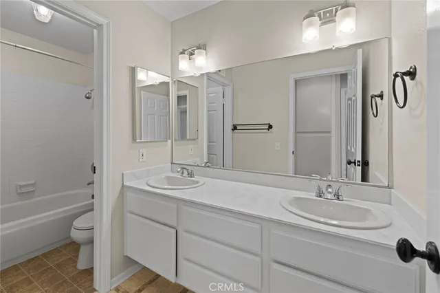 a bathroom with a sink double vanity granite tub and a mirror