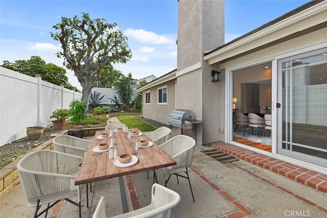 a view of a patio with table and chairs with wooden floor and fence
