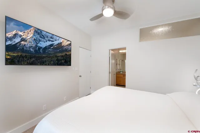 a bedroom with a bed and a painting on the wall