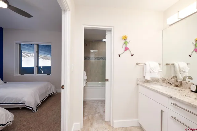 a en suite bathroom with a granite countertop sink and a mirror
