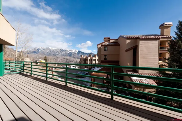 a view of a balcony with wooden floor and city view
