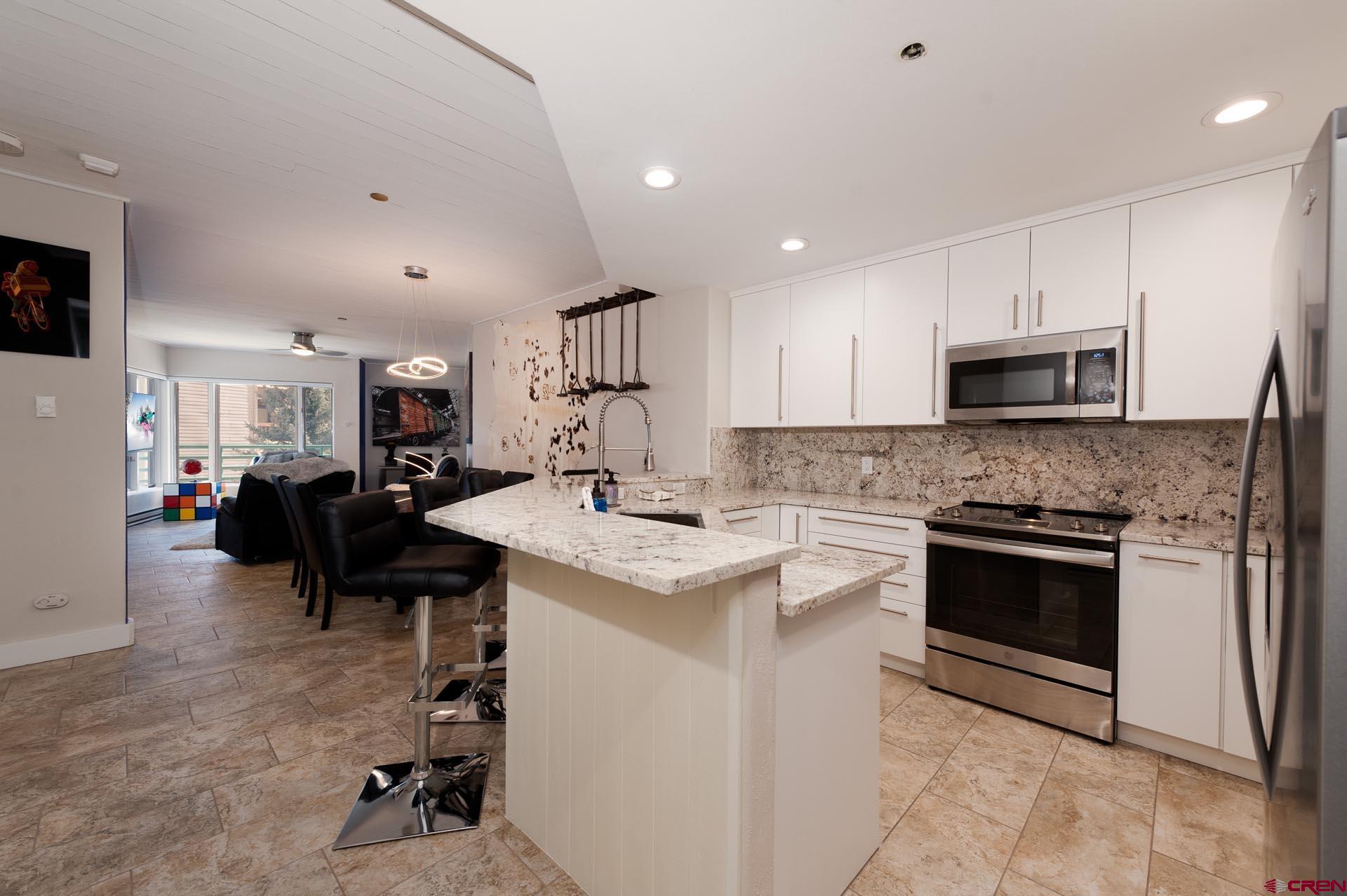 117 Needles Way, Unit 326 Durango, CO 81301 - Photo 7 of 35 a kitchen with granite countertop a sink appliances and cabinets