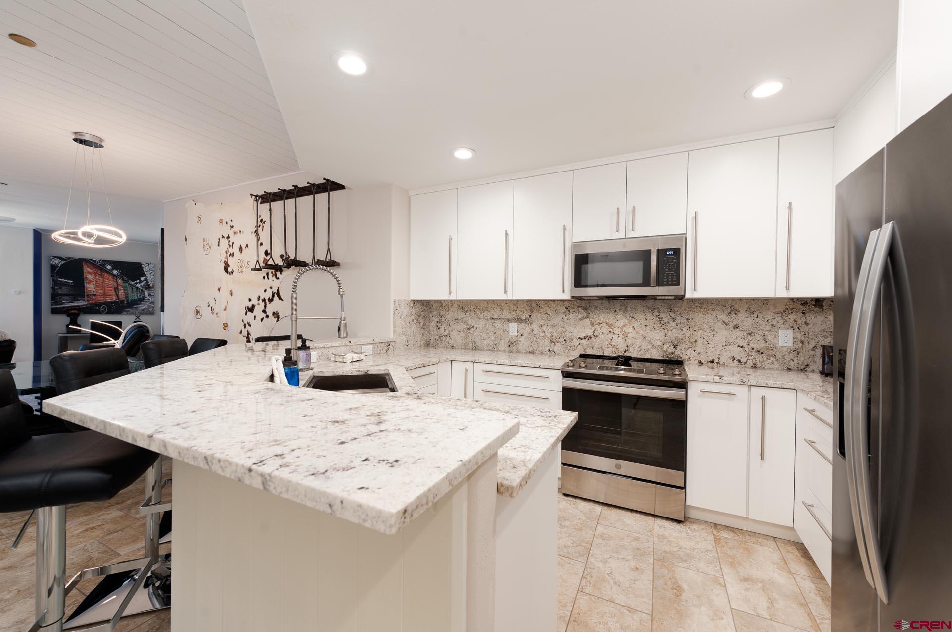 117 Needles Way, Unit 326 Durango, CO 81301 - Photo 8 of 35 a kitchen with kitchen island a sink stove and refrigerator
