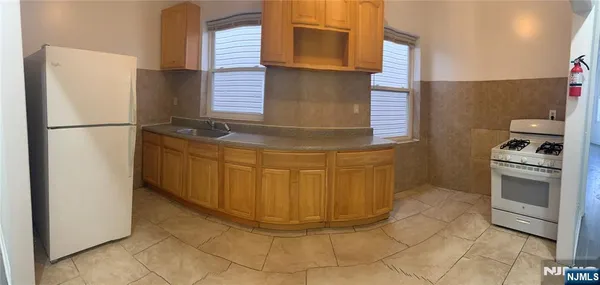 a kitchen with stainless steel appliances granite countertop a refrigerator and a stove