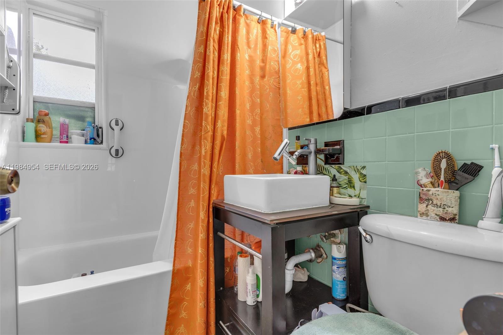 2490 Northwest 59th Street Miami, FL 33142 - Photo 15 of 37 a bathroom with a sink a toilet and a shower curtain