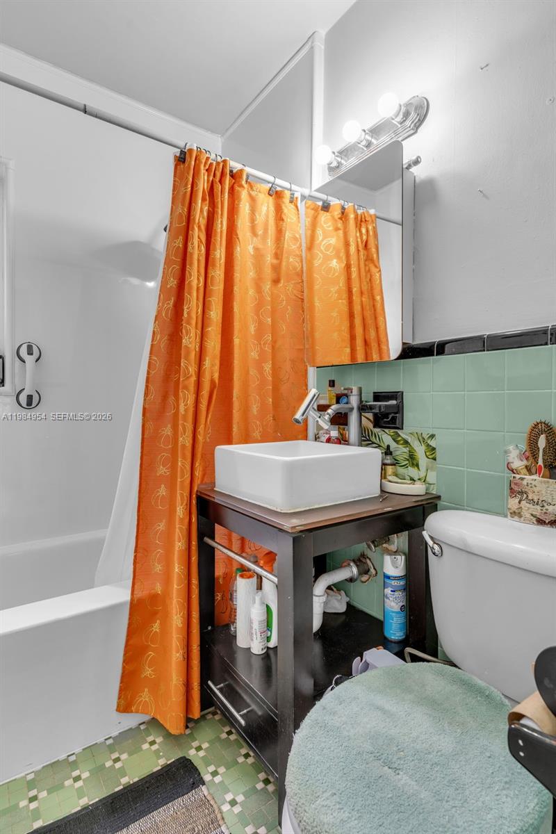 2490 Northwest 59th Street Miami, FL 33142 - Photo 16 of 37 a bathroom with a sink and a bathtub