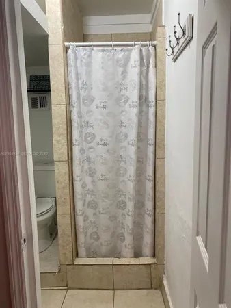 a white toilet sitting next to a white wall