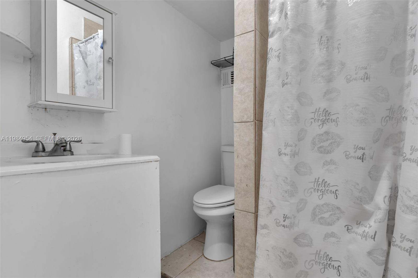 2490 Northwest 59th Street Miami, FL 33142 - Photo 29 of 37 a bathroom with a granite countertop toilet a sink and a mirror