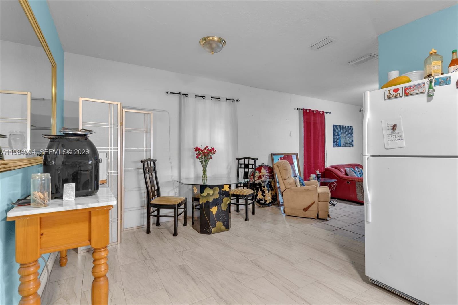 2490 Northwest 59th Street Miami, FL 33142 - Photo 6 of 37 a living room with furniture and a dining table with wooden floor