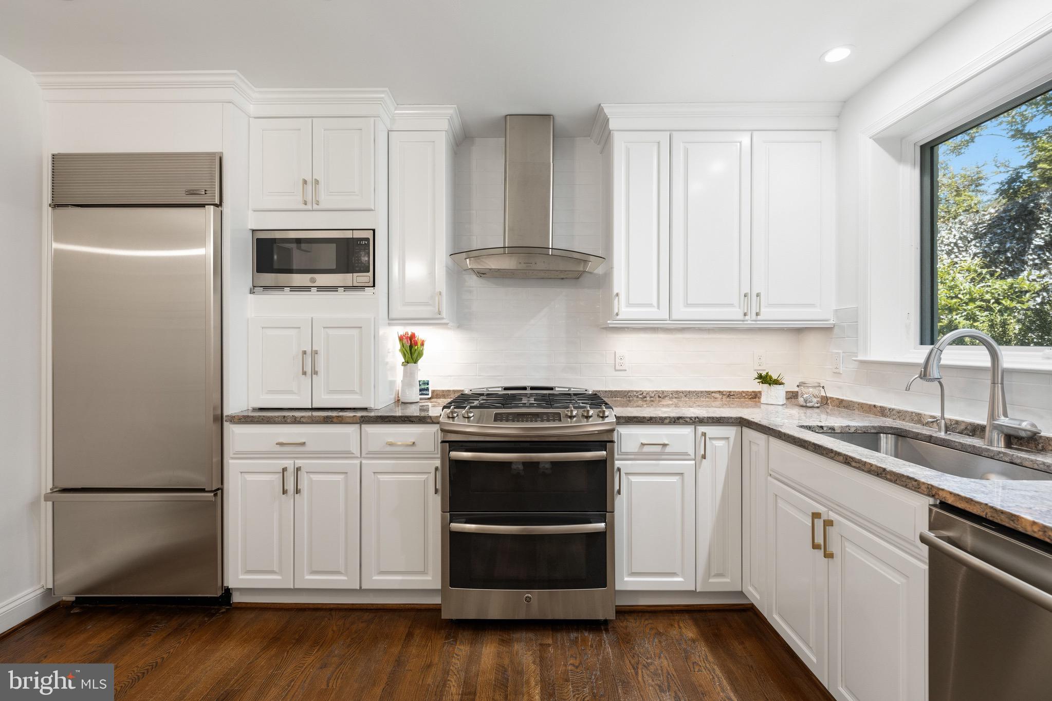 4555 W Street Northwest Washington, DC 20007 - Photo 7 of 34 a kitchen with cabinets stainless steel appliances and wooden floor