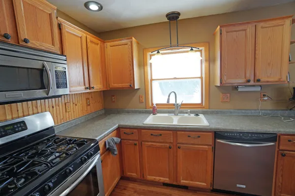 a kitchen with stainless steel appliances granite countertop a stove a sink and a microwave