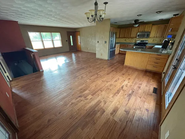 a view of wooden floor in a hall with a window