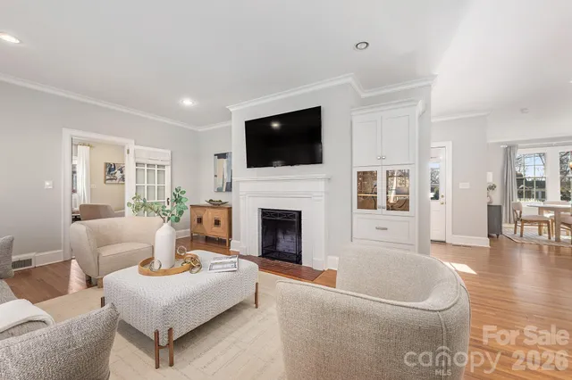 a living room with furniture fireplace and wooden floor