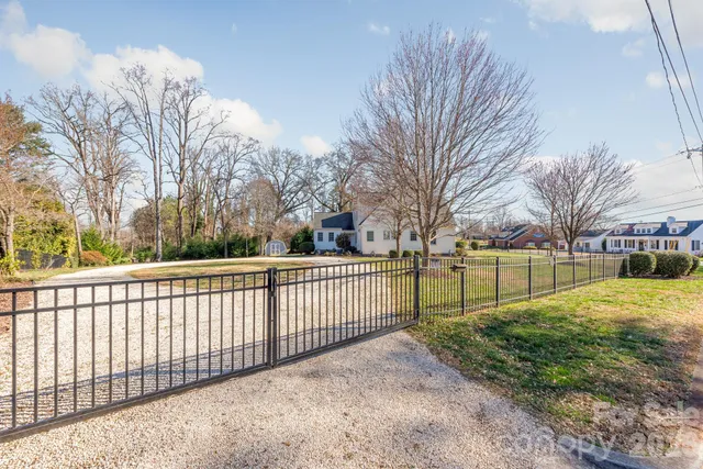a view of a yard with wooden fence