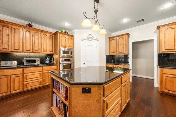 a kitchen with stainless steel appliances granite countertop a sink a stove and refrigerator