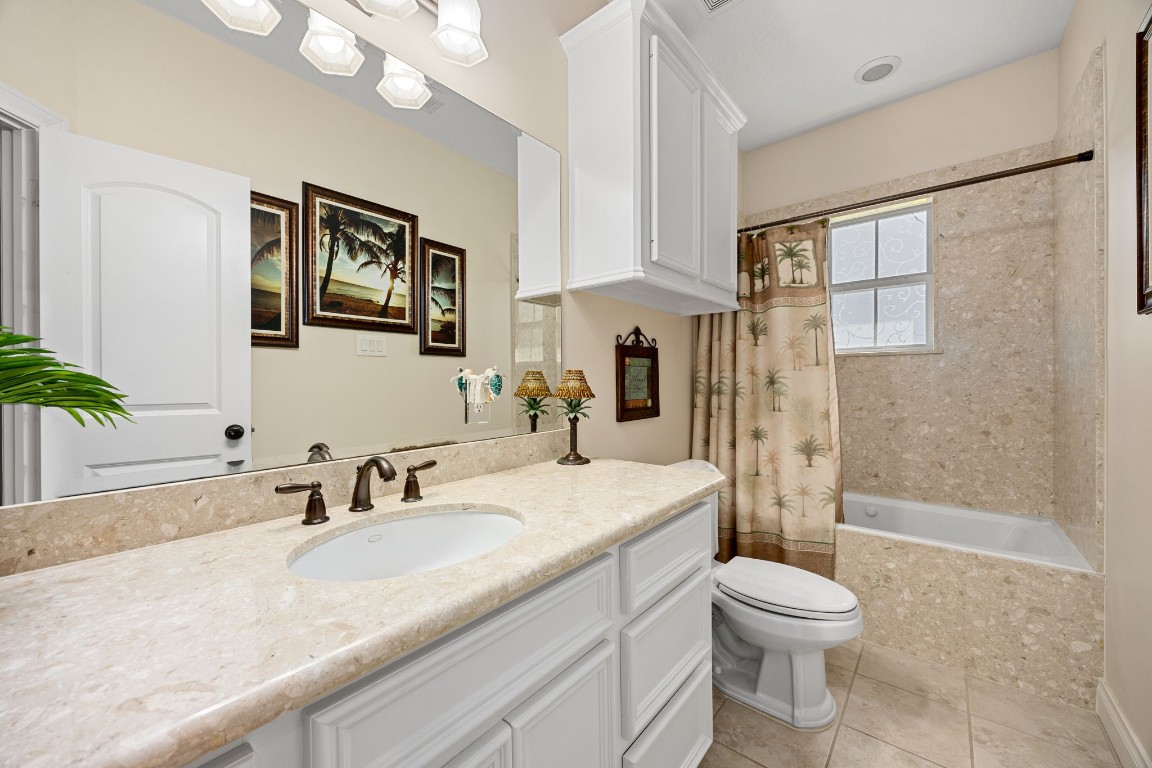 13506 Stagecoach Road Magnolia, TX 77355 - Photo 20 of 37 This elegant secondary bath features a granite vanity, custom cabinetry, and a beautifully tiled tub/shower combo, perfectly blending functionality with timeless style.