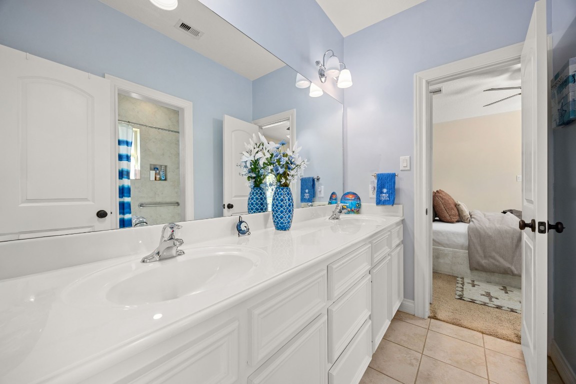 13506 Stagecoach Road Magnolia, TX 77355 - Photo 22 of 37 This Jack-and-Jill bath offers convenience and style with a dual-sink vanity, ample storage, and a neutral palette connecting two spacious bedrooms, perfect for guests or family.