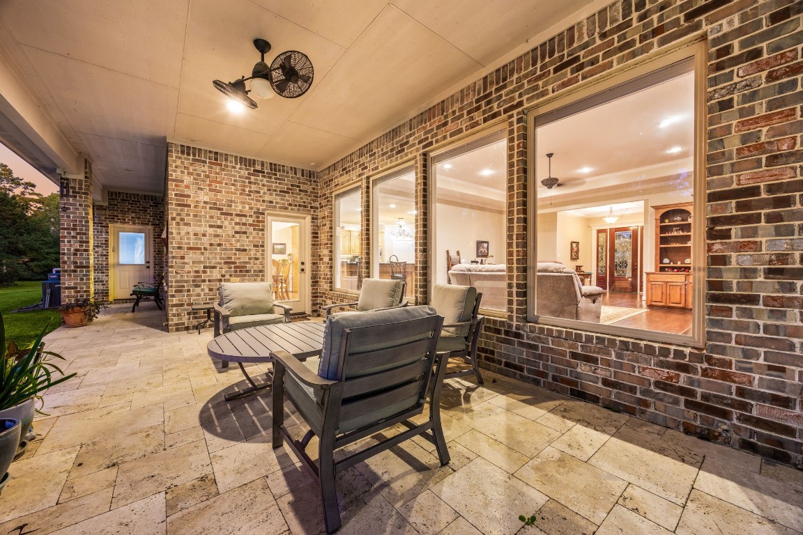 13506 Stagecoach Road Magnolia, TX 77355 - Photo 28 of 37 Enjoy peaceful evenings on the covered patio overlooking the serene, tree-lined backyard, perfect for relaxing or entertaining outdoors.