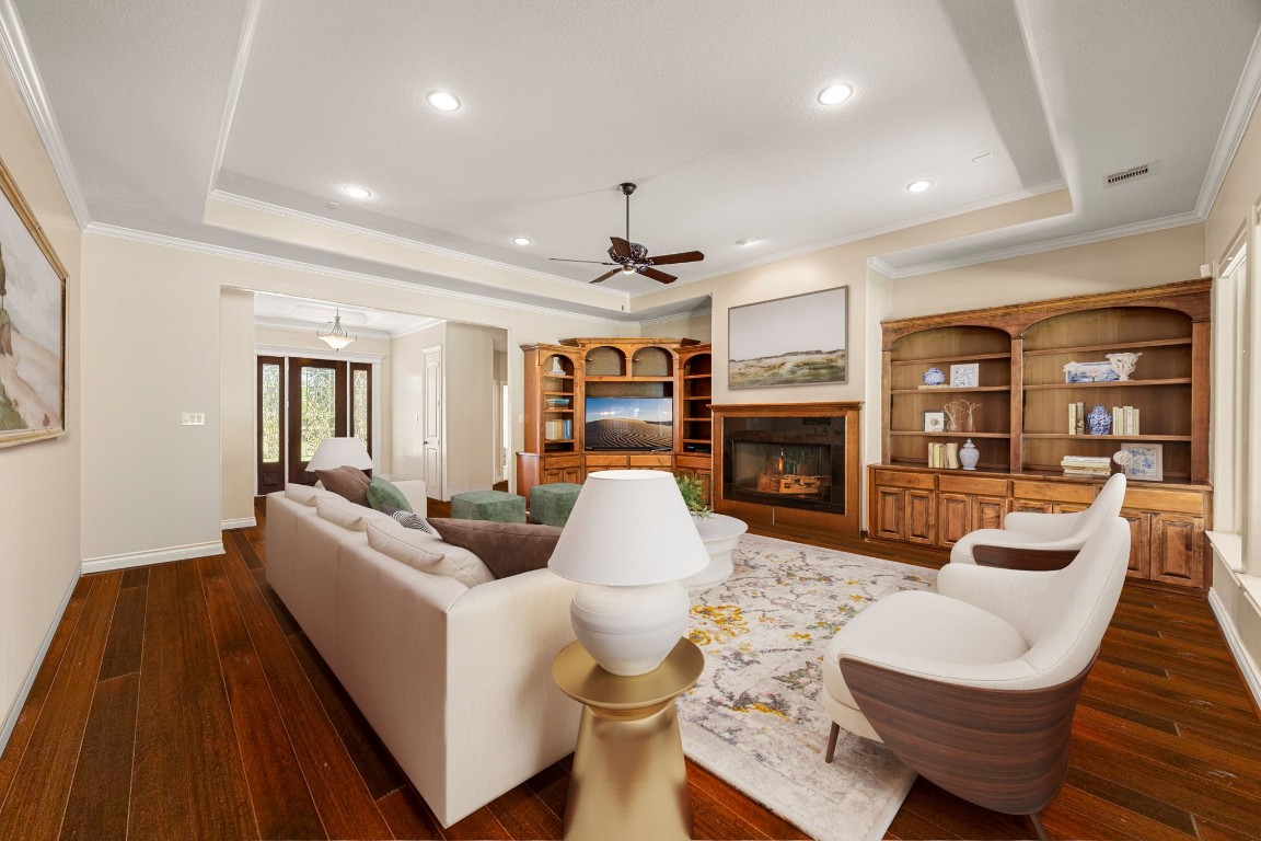 13506 Stagecoach Road Magnolia, TX 77355 - Photo 8 of 37 This beautiful living area features rich engineered hardwood flooring, elegant tray ceilings, and a warm fireplace framed by custom built-ins. Large windows fill the space with natural light, creating a bright and inviting ambiance. Perfectly positioned near the entryway, this room offers both comfort and sophistication for relaxing or entertaining.