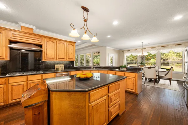 a kitchen with stainless steel appliances granite countertop sink stove and wooden cabinets