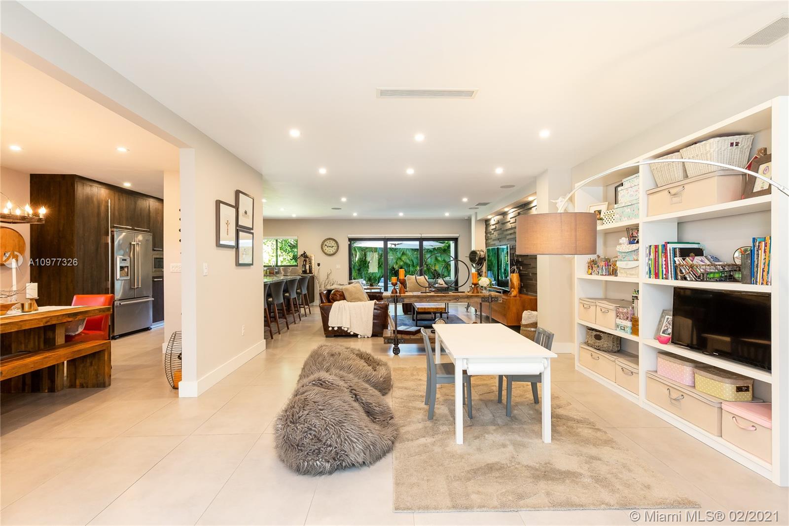 5185 Alton Road Miami Beach, FL 33140 - Photo 2 of 41 a living room with furniture and a flat screen tv