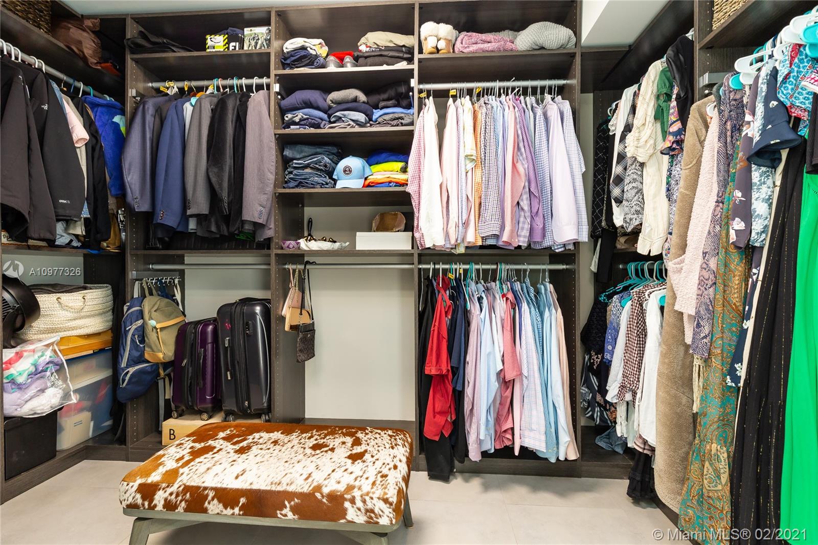 5185 Alton Road Miami Beach, FL 33140 - Photo 18 of 41 a view of walk in closet with clothes and shoes