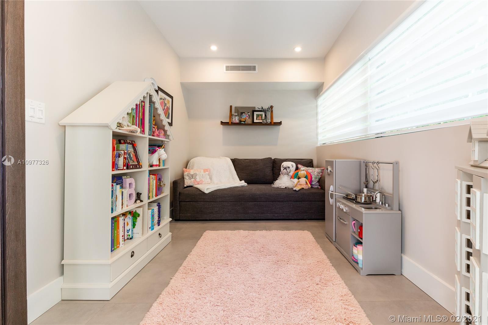 5185 Alton Road Miami Beach, FL 33140 - Photo 26 of 41 a living room with furniture and a book shelf