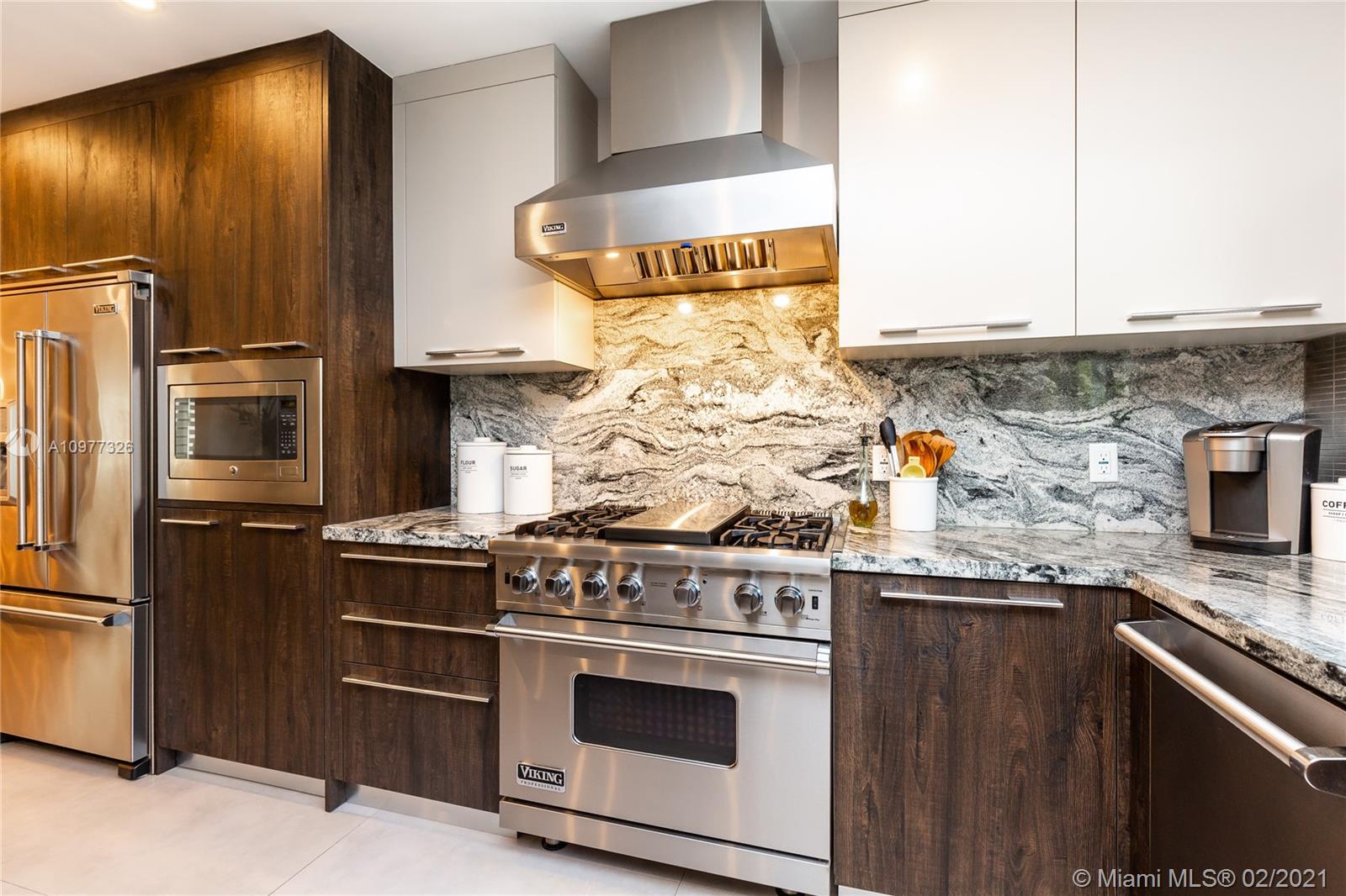 5185 Alton Road Miami Beach, FL 33140 - Photo 7 of 41 a kitchen with stainless steel appliances granite countertop a stove and a refrigerator