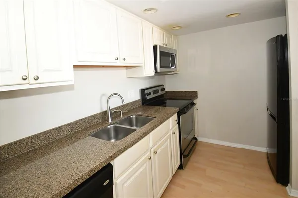 a kitchen with granite countertop a sink and a stove